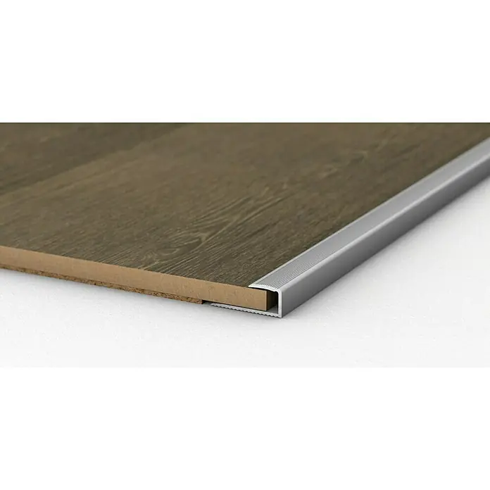 LOGOCLIC Endprofil 250 - Silber, 0,9 m x 24 mm x 12 mm, Montageart: Kleben - Das Bild zeigt ein Bodenprofil aus Aluminium, das an einer Holzbodenkante befestigt ist. Das Profil schützt und verleiht dem Boden ein sauberes Aussehen.