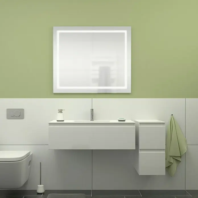 Camargue Espacio Badmöbel-Set L3 - 130 cm, Gama weiß glänzend - Badezimmer-Interieur mit einem beleuchteten Spiegel über einem weißen Waschtisch, einem Handtuch und einer Toilette, die ein modernes Design zeigt.