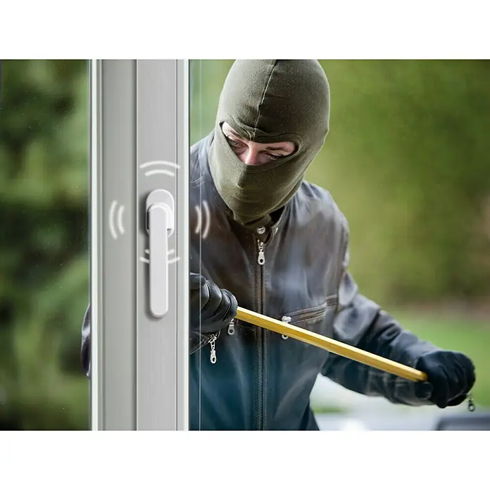 Schellenberg Manilla de ventana con alarma - Blanco, 115 dB - Un ladrón intenta forzar una ventana con una palanca mientras se activa un sensor de ventana.
