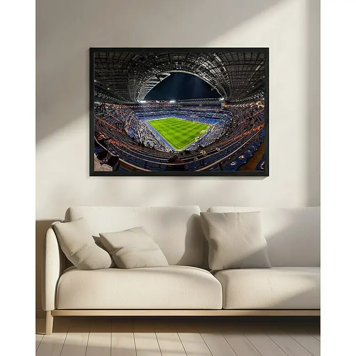 Papermoon Bild - Santiago Bernabèu, B x H: 110 x 80 cm, Ohne Passepartout, Rahmen Schwarz - Gerahmtes Bild eines Fußballstadions über einem beigen Sofa. Ein tolles Kunstwerk für Sportfans und zur Dekoration.