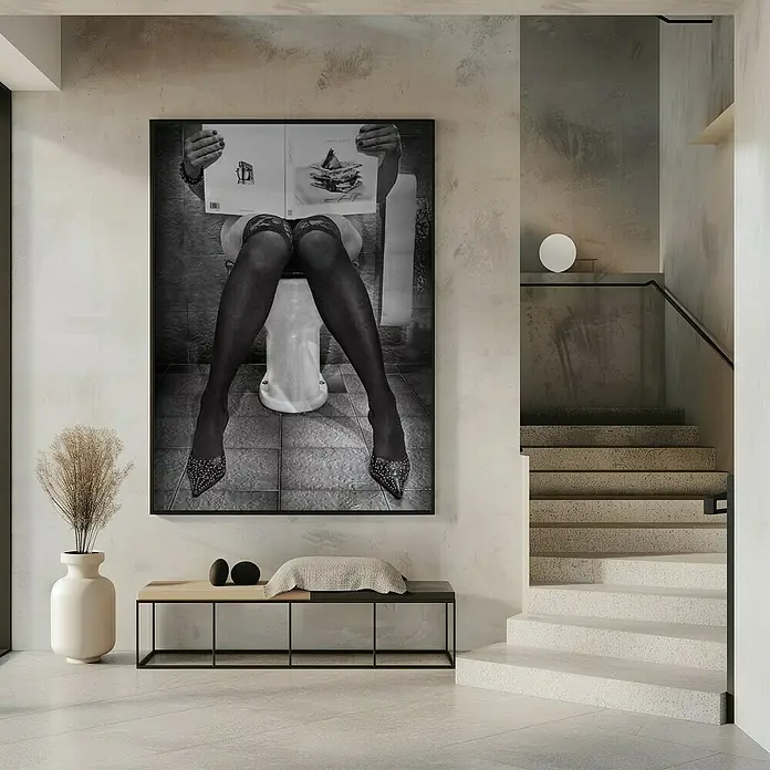 Papermoon Bild - Le Goart des Autres, B x H: 100 x 140 cm, Mit Passepartout, Rahmen Schwarz - Schwarzweißbild einer Frau mit Strapsen und Stöckelschuhen, die auf einer Toilette sitzt und ein Buch liest, gerahmt an einer Wand.