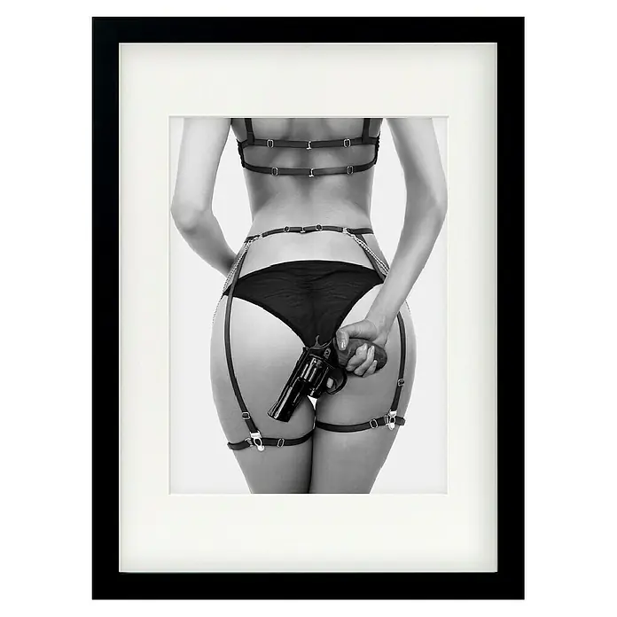 Papermoon Bild - Love & a loaded Gun, B x H: 40 x 50 cm, Mit Passepartout, Rahmen Schwarz - Gerahmtes Schwarz-Weiß-Foto einer Frau in Dessous mit einer Waffe, die eine kühne und provokative Atmosphäre ausstrahlt.