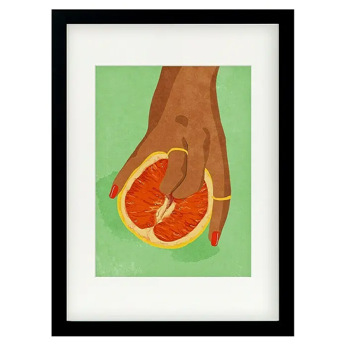Papermoon Bild - Fruitlover, B x H: 100 x 140 cm, Mit Passepartout, Rahmen Schwarz - Gerahmtes Bild mit einer Hand, die eine halbe Grapefruit hält, mit roten Nägeln und goldenen Ringen, vor einem grünen Hintergrund.