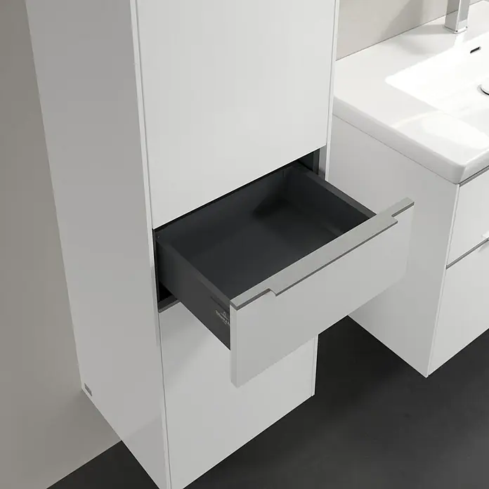 Villeroy & Boch Subway 3.0 Hochschrank - B x T x H: 40 x 36,2 x 171 cm, 1x Schublade, 2x Tür, Brilliant White, Farbe Griff: Aluminium glänzend, DIN Anschlag: Links - Moderne Badezimmerkommode in Weiß mit einer offenen Schublade, die das graue Innere zeigt, neben einem weißen Waschbeckenunterschrank.