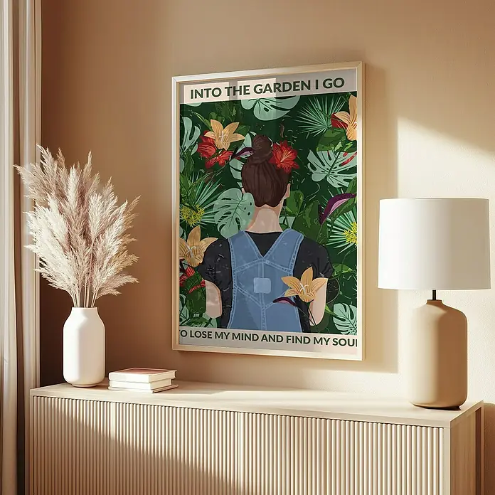 Papermoon Bild - Into the Garden, B x H: 100 x 140 cm, Ohne Passepartout, Rahmen Eiche - Poster "Into the Garden I Go", das eine Frau in Gartengeräten vor üppigem Grün zeigt, hängt an der Wand über einem Sideboard.