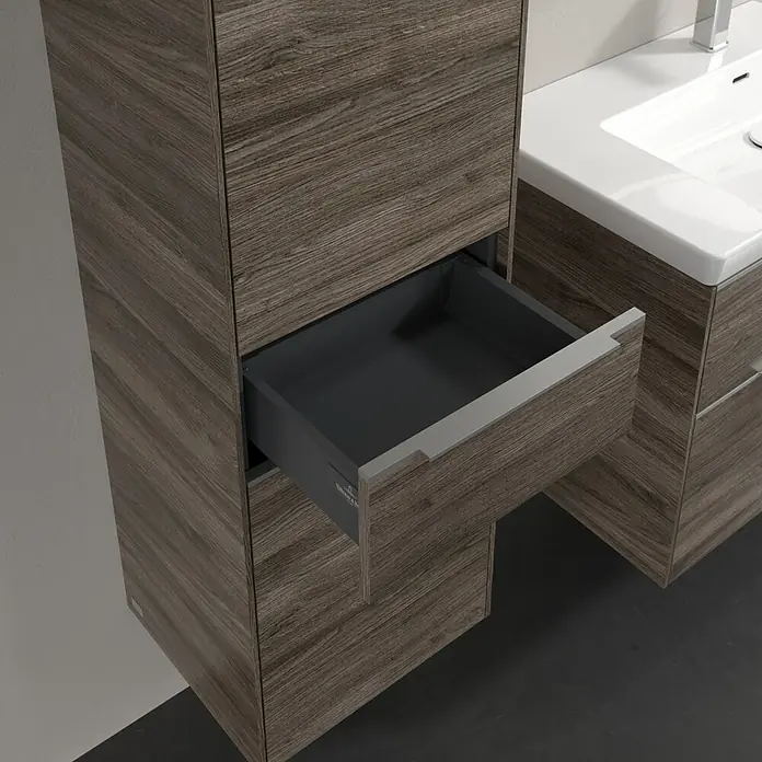 Villeroy & Boch Subway 3.0 Hochschrank - B x T x H: 40 x 36,2 x 171 cm, 1x Schublade, 2x Tür, Stone Oak, Farbe Griff: Aluminium glänzend, DIN Anschlag: Links - Nahaufnahme eines Badezimmerschranks mit offenem Auszug. Das Holzdekor und das minimalistische Design verleihen dem Bad eine moderne Note.