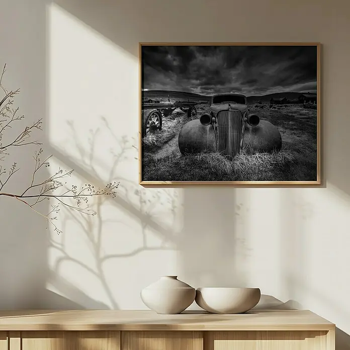 Papermoon Bild - Too Old to Drive, B x H: 80 x 60 cm, Mit Passepartout, Rahmen Eiche - Gerahmtes Schwarz-Weiß-Foto eines alten Autos auf einer Wand, das eine Vintage- und künstlerische Atmosphäre vermittelt.