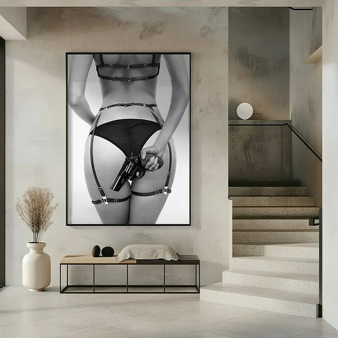 Papermoon Bild - Love & a loaded Gun, B x H: 50 x 70 cm, Ohne Passepartout, Rahmen Schwarz - Schwarz-Weiß-Fotografie mit einer Frau, die ein Halfter trägt und eine Pistole hält, als Wandschmuck in einem stilvollen Interieur.