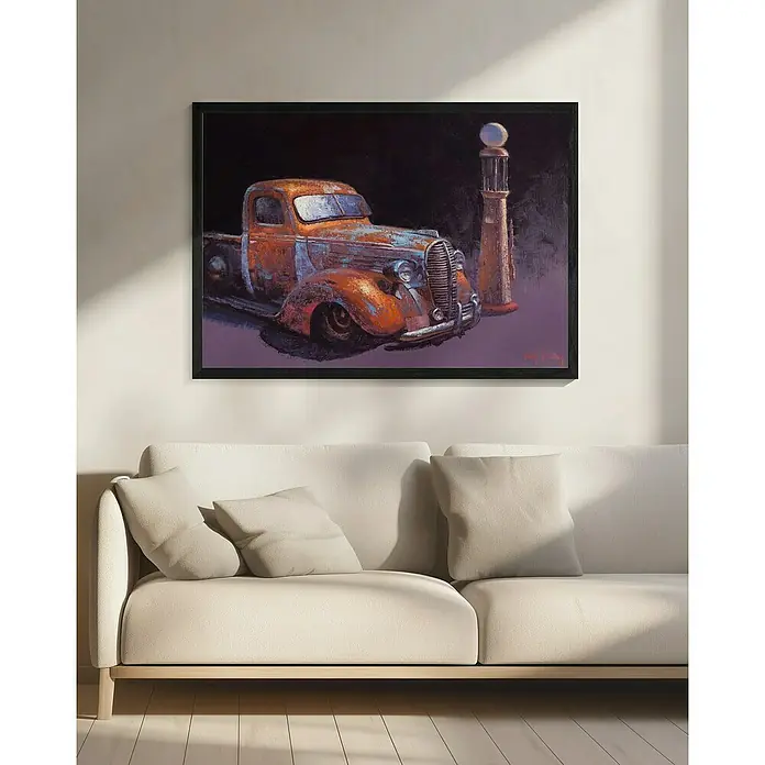 Papermoon Bild - Rusted Pickup Truck, B x H: 80 x 60 cm, Mit Passepartout, Rahmen Schwarz - Gerahmtes Gemälde eines Oldtimer-Trucks und einer Zapfsäule, das über einem cremefarbenen Sofa hängt.