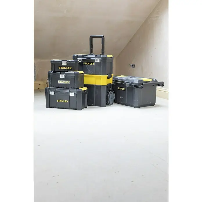 Stanley Juego de cajas de herramientas STST1-81065 - 3 pzs., No incluye herramientas - Una variedad de tamaños de cajas de herramientas de la marca Stanley negras y amarillas alineadas en una habitación.