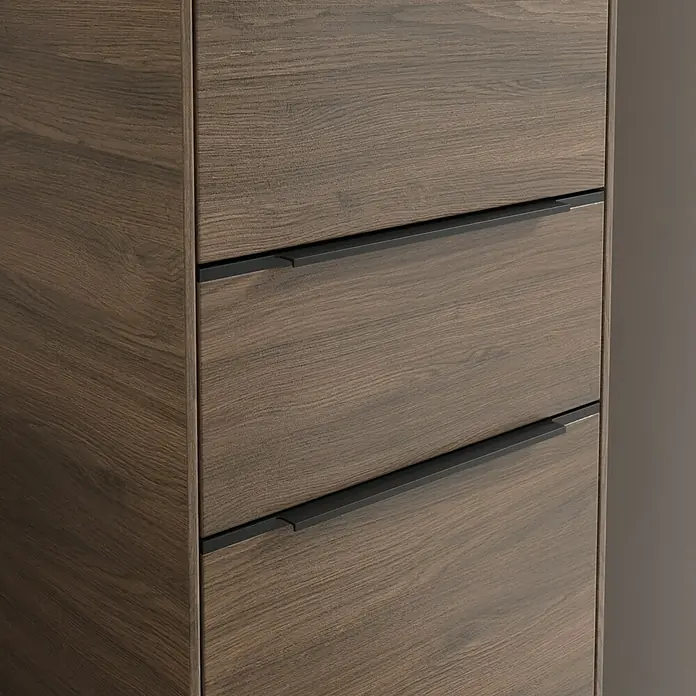 Villeroy & Boch Subway 3.0 Hochschrank - B x T x H: 40 x 36,2 x 171 cm, 1x Schublade, 2x Tür, Arizona Oak, Farbe Griff: Volcano black, DIN Anschlag: Rechts - Nahaufnahme einer modernen Kommode mit drei Schubladen und dunklen Holzmaserung. Die Griffe sind schlicht und schwarz.