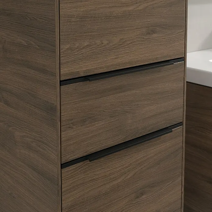 Villeroy & Boch Subway 3.0 Hochschrank - B x T x H: 40 x 36,2 x 171 cm, 1x Schublade, 2x Tür, Arizona Oak, Farbe Griff: Volcano black, DIN Anschlag: Links - Nahaufnahme eines Badezimmerschranks mit drei Schubladen in dunkler Holzoptik und schwarzen Griffen.