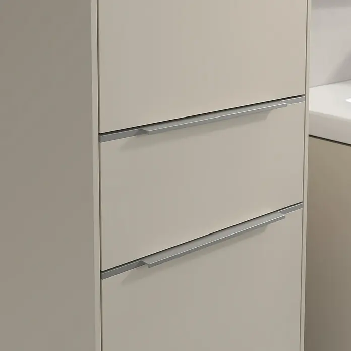 Villeroy & Boch Subway 3.0 Hochschrank - B x T x H: 40 x 36,2 x 171 cm, 1x Schublade, 2x Tür, Cashmere Grey, Farbe Griff: Aluminium glänzend, DIN Anschlag: Links - Nahaufnahme eines hellbeigen Badezimmerschranks mit drei Schubladen und modernen, silbernen Griffen, der ein elegantes und aufgeräumtes Design zeigt.