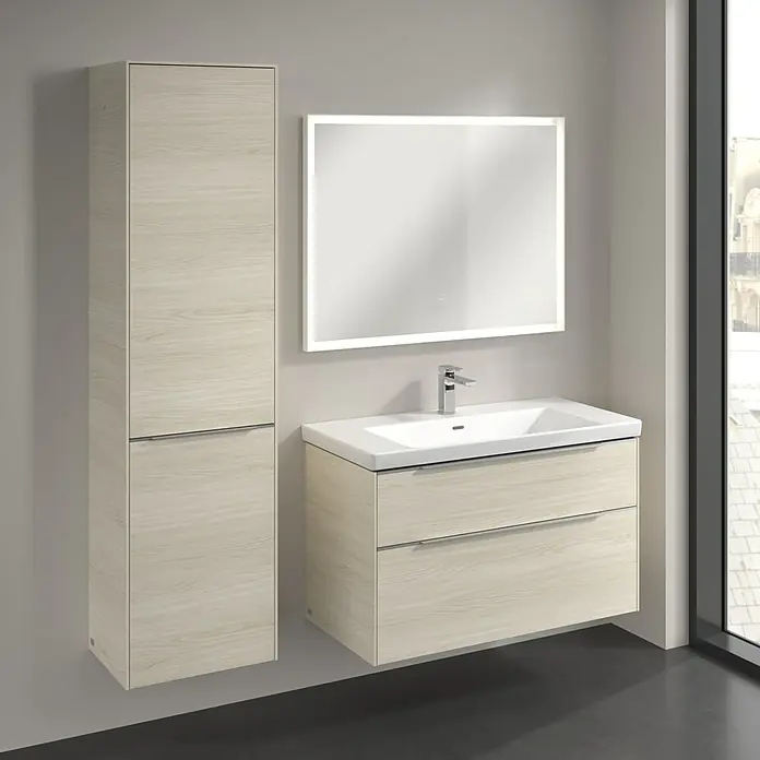 Villeroy & Boch Subway 3.0 Hochschrank - B x T x H: 40 x 36,2 x 171 cm, 1x Klappe mit Wäschekorb, 1x Tür, White Oak, Farbe Griff: Aluminium glänzend, DIN Anschlag: Links - Ein stilvolles Badezimmerensemble mit einem hellen Holzwaschtisch mit zwei Schubladen, einem passenden Hochschrank und einem beleuchteten Spiegel.