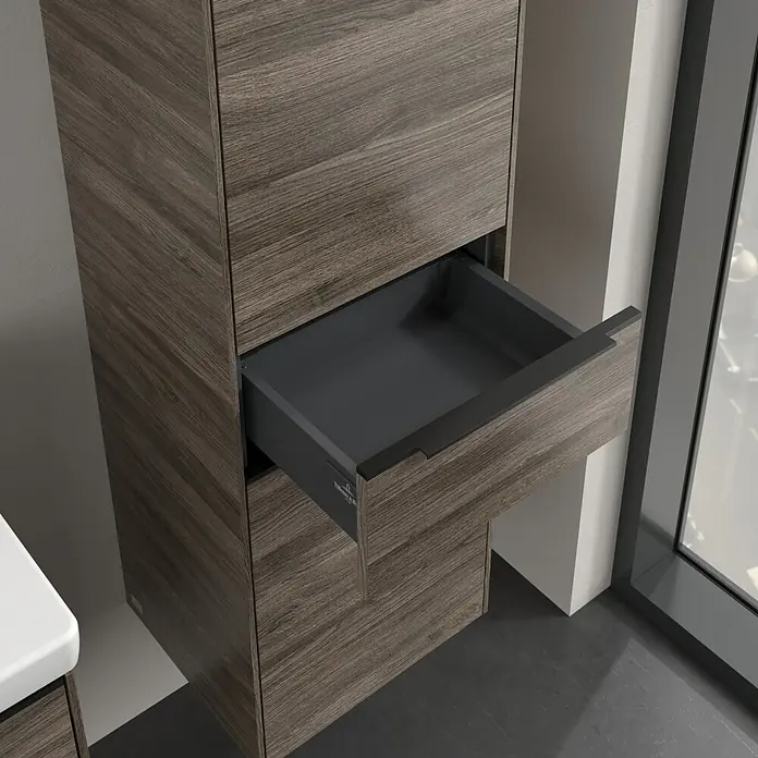 Villeroy & Boch Subway 3.0 Hochschrank - B x T x H: 40 x 36,2 x 171 cm, 1x Schublade, 2x Tür, Stone Oak, Farbe Griff: Volcano black, DIN Anschlag: Rechts - Detailaufnahme eines offenen Schubladenelements in Holzoptik, integriert in ein modernes Badezimmermöbel. Die Schublade ist grau und hat einen schwarzen Griff.
