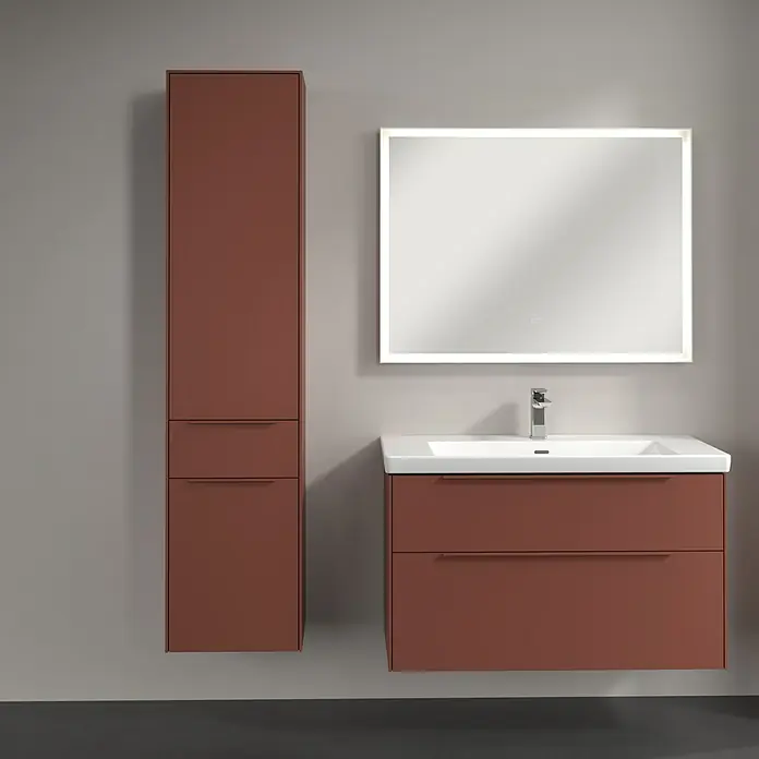 Villeroy & Boch Subway 3.0 Hochschrank - B x T x H: 40 x 36,2 x 171 cm, 1x Schublade, 2x Tür, Wine Red, Farbe Griff: Wine Red, DIN Anschlag: Links - Ein modernes Badezimmer-Set in einem warmen Terrakotta-Ton mit einem Waschtischunterschrank, einem Hochschrank und einem beleuchteten Spiegel.