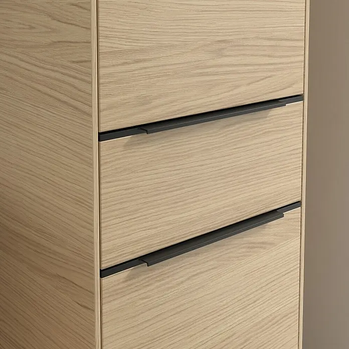 Villeroy & Boch Subway 3.0 Hochschrank - B x T x H: 40 x 36,2 x 171 cm, 1x Schublade, 2x Tür, Nordik oak, Farbe Griff: Volcano black, DIN Anschlag: Rechts - Detailaufnahme eines Holzschranks mit modernen, schwarzen Griffen, die das schlichte Design des Möbelstücks hervorheben.