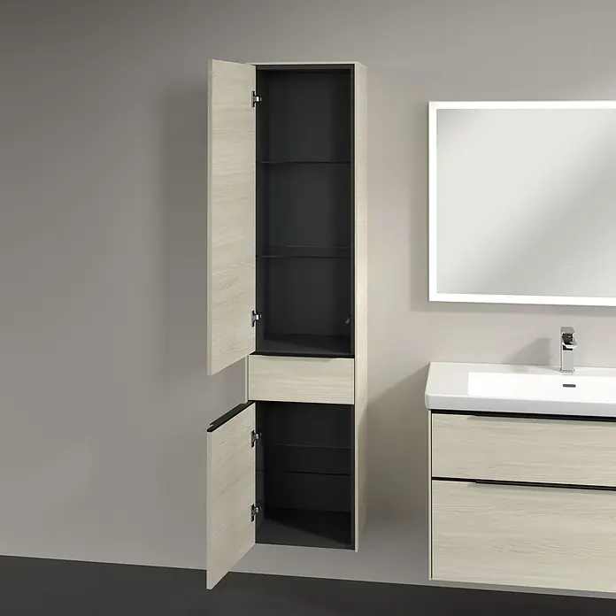 Villeroy & Boch Subway 3.0 Hochschrank - B x T x H: 40 x 36,2 x 171 cm, 1x Schublade, 2x Tür, White Oak, Farbe Griff: Volcano black, DIN Anschlag: Links - Ein offener, heller Holzschrank mit dunklem Innenraum und Glasböden neben einem Waschbecken und einem beleuchteten Spiegel.