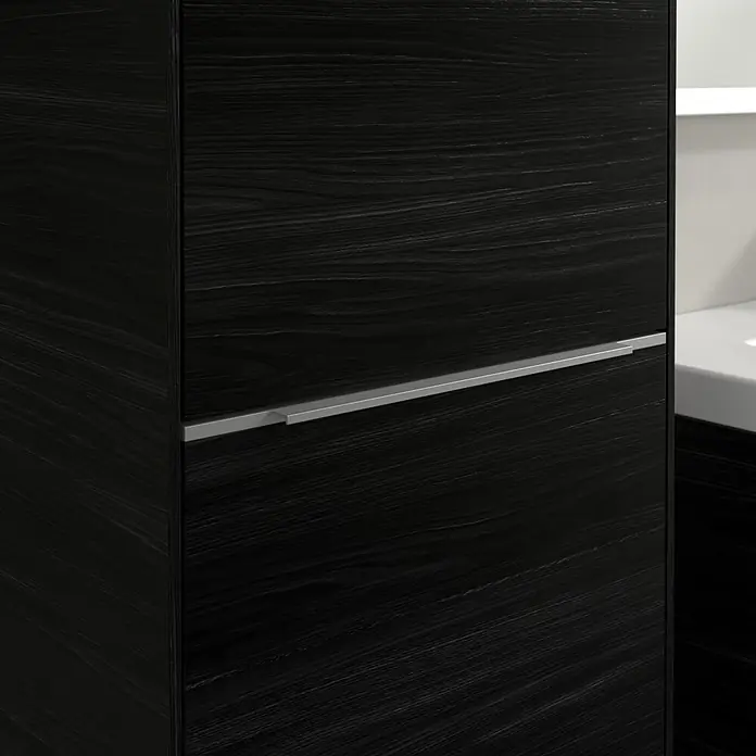 Villeroy & Boch Subway 3.0 Hochschrank - B x T x H: 40 x 36,2 x 171 cm, 1x Klappe mit Wäschekorb, 1x Tür, Black Oak, Farbe Griff: Aluminium glänzend, DIN Anschlag: Links - Nahaufnahme eines schwarzen Holzschranks mit Schublade und silbernem Griff, der elegante Details und Textur hervorhebt.