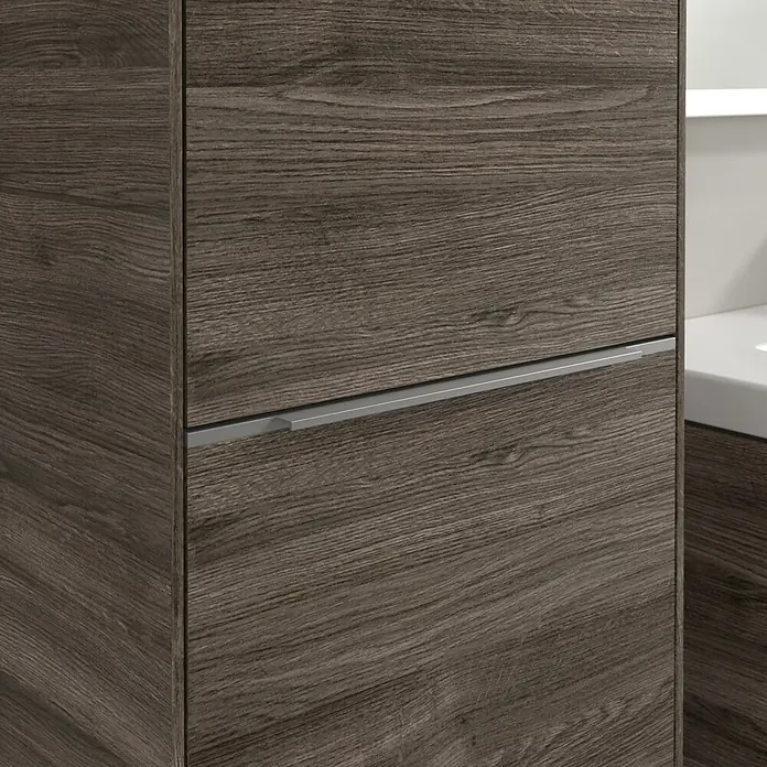 Villeroy & Boch Subway 3.0 Hochschrank - B x T x H: 40 x 36,2 x 171 cm, 1x Klappe mit Wäschekorb, 1x Tür, Stone Oak, Farbe Griff: Aluminium glänzend, DIN Anschlag: Links - Nahaufnahme eines modernen Badezimmerschranks mit Holzstruktur und einem schlanken, silbernen Griff, der Stil und Funktionalität vereint.
