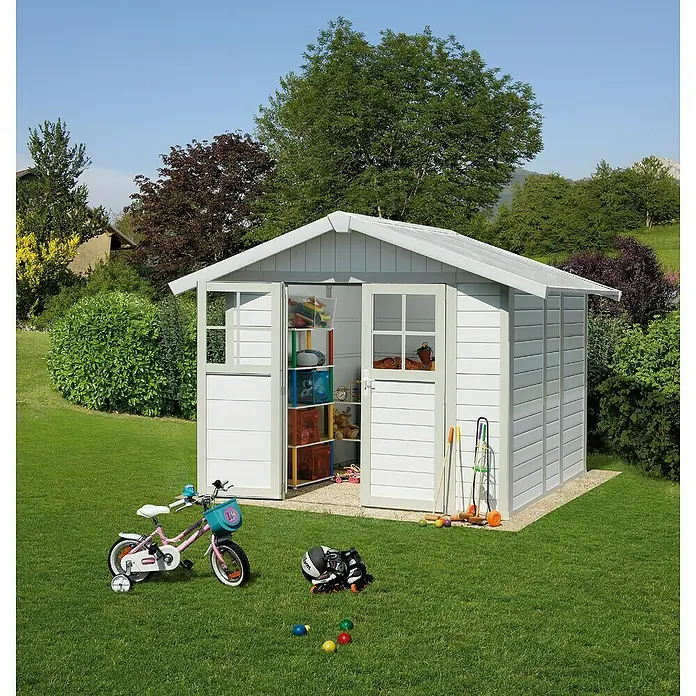 Grosfillex Caseta para jardín Deco - Medidas ext. (An x Pr): 295 x 261 cm, Plástico, Blanco, 4,9 m² - Imagen de una caseta de jardín blanca y espaciosa con puertas abiertas, rodeada de juguetes y herramientas de jardinería sobre césped cuidado.