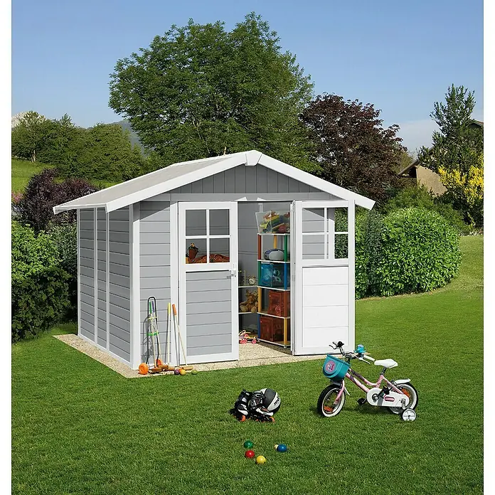 Grosfillex Caseta para jardín Deco - Medidas ext. (An x Pr): 295 x 261 cm, Plástico, Gris claro, 4,9 m² - Una caseta de jardín gris con detalles blancos, puertas abiertas que revelan juguetes dentro, situada en un césped.