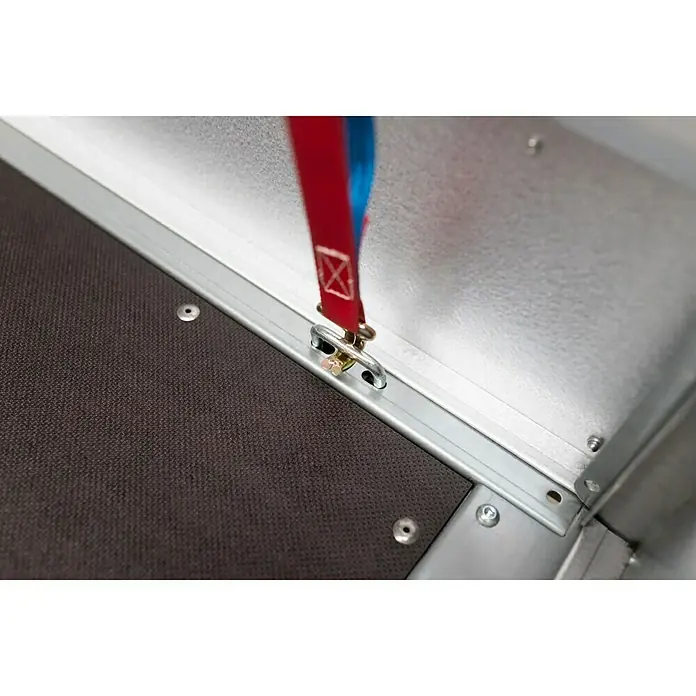 Stema Anhänger BASIC SH 1000-25-13.1 - Nutzlast: 764 kg, Einachser, Kasteninnenmaß: 251 x 128 x 35 cm, Gebremst - Detailansicht eines Zurrpunkts mit rotem Band an einer LKW-Ladefläche, der zur Ladungssicherung dient.