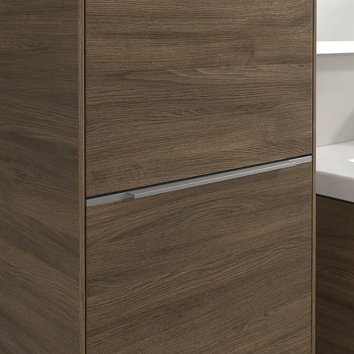 Villeroy & Boch Subway 3.0 Hochschrank - B x T x H: 40 x 36,2 x 171 cm, 1x Klappe mit Wäschekorb, 1x Tür, Arizona Oak, Farbe Griff: Aluminium glänzend, DIN Anschlag: Links - Nahaufnahme eines modernen Badezimmerschranks mit Holzmaserung und schlankem, silbernem Griff. Stilvolles Design für Badezimmer.