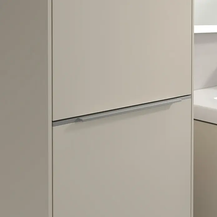 Villeroy & Boch Subway 3.0 Hochschrank - B x T x H: 40 x 36,2 x 171 cm, 1x Klappe mit Wäschekorb, 1x Tür, Cashmere Grey, Farbe Griff: Aluminium glänzend, DIN Anschlag: Links - Nahaufnahme von Badmöbeln mit dezentem, modernem Griff, der die schlichte Eleganz des Designs betont.