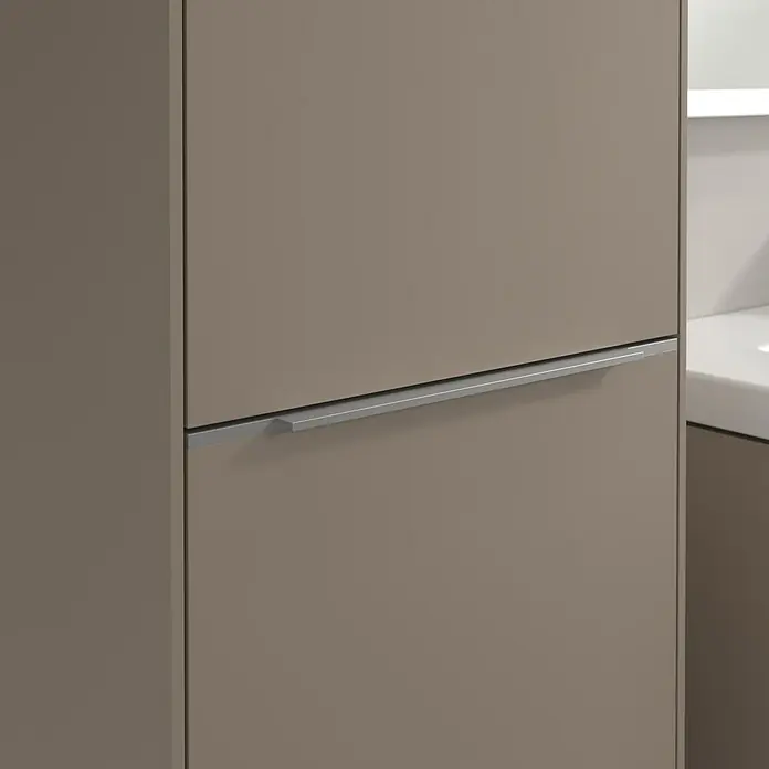 Villeroy & Boch Subway 3.0 Hochschrank - B x T x H: 40 x 36,2 x 171 cm, 1x Klappe mit Wäschekorb, 1x Tür, Taupe, Farbe Griff: Aluminium glänzend, DIN Anschlag: Links - Nahaufnahme eines modernen Schranks in einem Braunton mit einem schmalen, horizontalen, silberfarbenen Griff. Elegantes Design für moderne Interieurs.