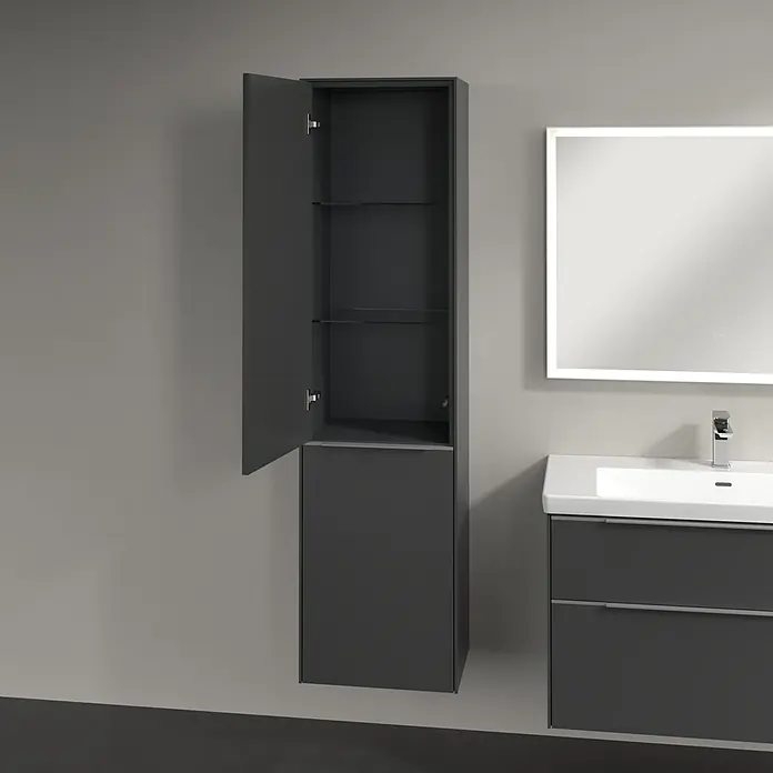 Villeroy & Boch Subway 3.0 Hochschrank - B x T x H: 40 x 36,2 x 171 cm, 1x Klappe mit Wäschekorb, 1x Tür, Graphite, Farbe Griff: Aluminium glänzend, DIN Anschlag: Links - Badezimmerschrank in Anthrazit mit geöffneter Tür, neben einem Waschtisch mit Spiegel. Moderne Badmöbel für stilvolle Badezimmer.