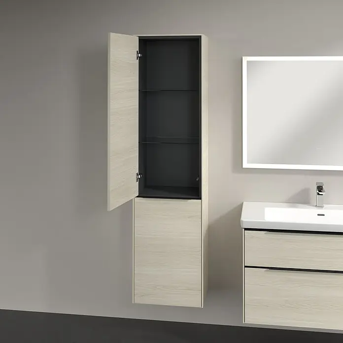Villeroy & Boch Subway 3.0 Hochschrank - B x T x H: 40 x 36,2 x 171 cm, 1x Klappe mit Wäschekorb, 1x Tür, White Oak, Farbe Griff: Volcano black, DIN Anschlag: Links - Bild eines offenen, hölzernen Badezimmerschranks mit Glasböden, neben einem Waschbecken und einem Spiegel.