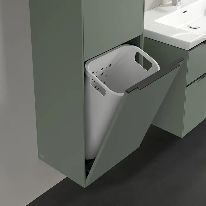 Villeroy & Boch Subway 3.0 Hochschrank - B x T x H: 40 x 36,2 x 171 cm, 1x Klappe mit Wäschekorb, 1x Tür, Soft Green, Farbe Griff: Volcano black, DIN Anschlag: Links - Helle Wäschetonne in einem Badezimmerschrank. Die Tür des Schranks ist geöffnet und gibt den Blick auf die Wäschetonne frei.