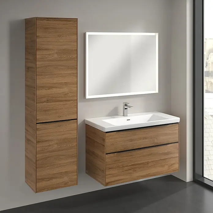 Villeroy & Boch Subway 3.0 Hochschrank - B x T x H: 40 x 36,2 x 171 cm, 1x Klappe mit Wäschekorb, 1x Tür, Kansas Oak, Farbe Griff: Volcano black, DIN Anschlag: Links - Ein modernes Badezimmer-Set mit einem Waschtischunterschrank und einem hochschrank im Holzdekor, sowie einem beleuchteten Spiegel.