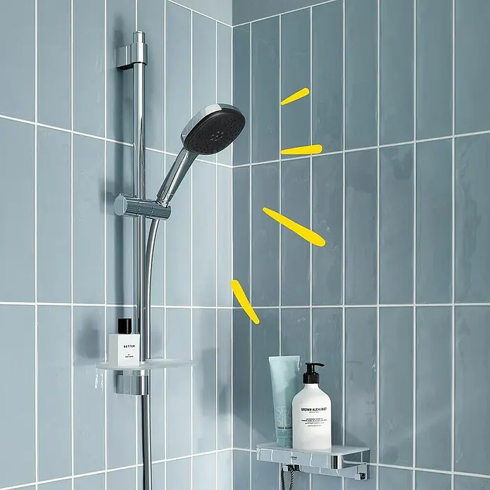 Grohe QuickFix Brausegarnitur - Lochabstand: 47 cm - 62 cm, Anzahl Strahlarten: 2 Stk. - Ein modernes Badezimmer mit einer Duscharmatur mit Seifenablage und Pflegeprodukten auf gefliesten Wänden.