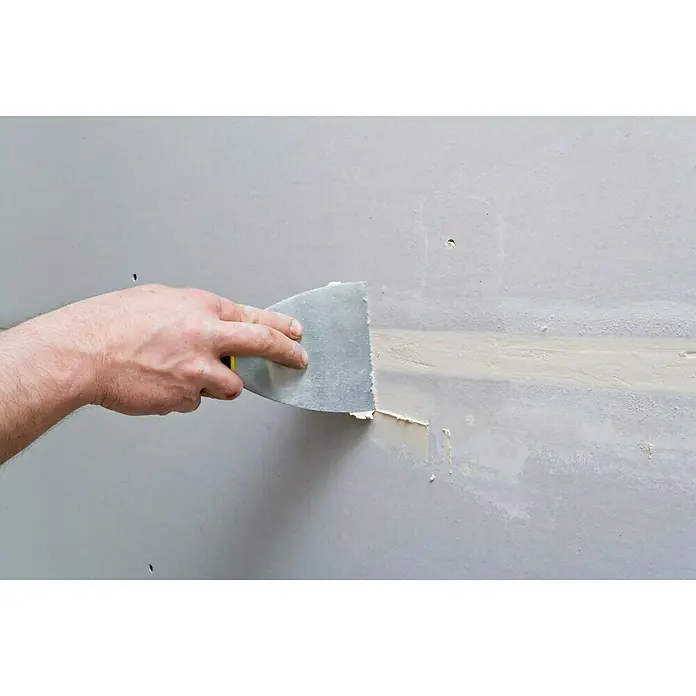 Knauf Feinspachtel Uniflott Finish - 4 kg, Gebrauchsfertig - Einarmige Person glättet Spachtelmasse mit einem Spachtel auf einer Wand, um Löcher oder Risse zu füllen. Werkzeug für Renovierungsarbeiten.