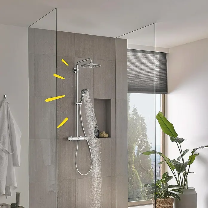Grohe Vitalio Joy Duschsystem 260 - Mit Thermostatarmatur, Lochabstand: 100,5 cm, Anzahl Strahlarten: 3 Stk., Chrom - Das Bild zeigt eine moderne Dusche mit Kopf- und Handbrause. Der Duschkopf ist rund und verchromt, die Handbrause ist an einer Stange befestigt.
