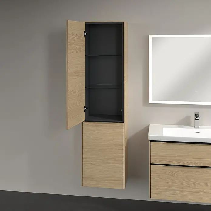 Villeroy & Boch Subway 3.0 Hochschrank - B x T x H: 40 x 36,2 x 171 cm, 1x Klappe mit Wäschekorb, 1x Tür, Nordik oak, Farbe Griff: Volcano black, DIN Anschlag: Links - Ein hoher, hellholzfarbener Badezimmerschrank mit offener Tür und Glasböden. Das Innere des Schranks ist dunkelgrau, passend zu dem Waschtischunterschrank.