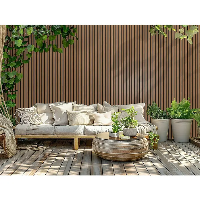 Wandpaneel Outdoor - Light Brown, WPC, 2.350 x 219 x 26 mm - Eine gemütliche Sitzecke im Freien mit einer grauen Couch, Kissen und einem runden Couchtisch, umgeben von Pflanzen und einem Holzboden.
