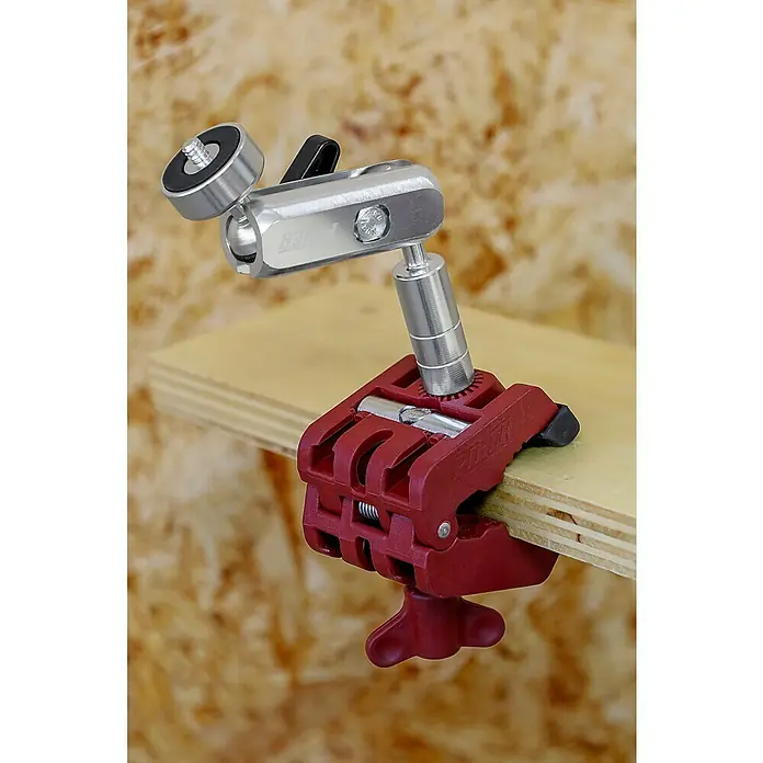 Piher Soporte universal 34061 - Anchura de expansión: 1,8 cm - 4,8 cm, Apertura máxima: 48 mm - Primer plano de una abrazadera Manfrotto roja con un adaptador de rótula plateado, sujeta a una tabla de madera.