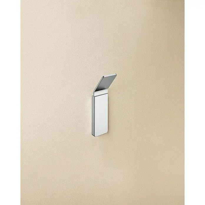 Cosmic Toallero de gancho Nea - 1 ud., Cromo, Brillante - Perchero de pared de acero inoxidable cepillado, diseño moderno. El perchero está montado en una pared beige para guardar toallas o chaquetas.