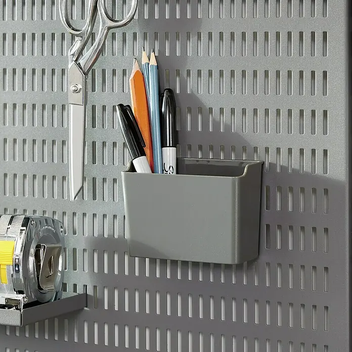 Elfa Garage+ by Elfa Kleinteileeinsatz Becher für Lochwand - L x B x H: 5,9 x 11,2 x 8 cm, Grau matt - Das Bild zeigt eine graue Lochwand mit einem Behälter, einer Schere, einem Massband und Stiften. Die Lochwand dient als Aufbewahrungssystem.