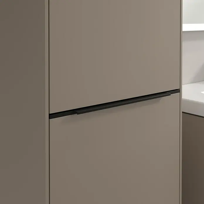 Villeroy & Boch Subway 3.0 Hochschrank - B x T x H: 40 x 36,2 x 171 cm, 1x Klappe mit Wäschekorb, 1x Tür, Taupe, Farbe Griff: Volcano black, DIN Anschlag: Links - Nahaufnahme eines modernen, horizontalen, mattschwarzen Schranks mit Griffen in einer stilvollen, hellbraunen Farbe.