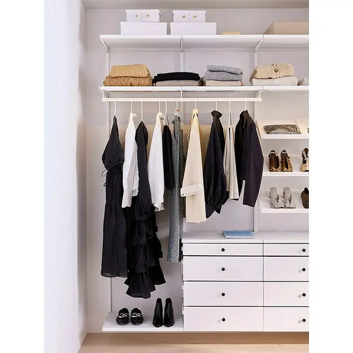 Elfa Décor+ by Elfa Schubladenfront - L x B x H: 1,5 x 60 x 8,8 cm, Weiß - Ein begehbarer Kleiderschrank mit Kleidung, Schuhen, Aufbewahrungsboxen und einem weißen Schubladenelement mit schwarzen Knöpfen.