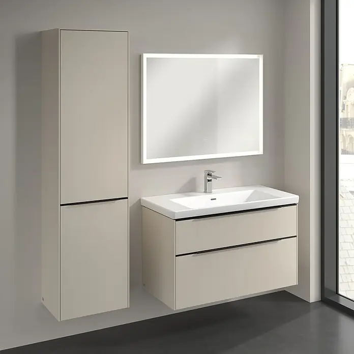 Villeroy & Boch Subway 3.0 Hochschrank - B x T x H: 40 x 36,2 x 171 cm, 1x Klappe mit Wäschekorb, 1x Tür, Cashmere Grey, Farbe Griff: Volcano black, DIN Anschlag: Links - Bild einer Badezimmereinrichtung mit einem Waschtisch mit zwei Schubladen, einem hochschrank und einem beleuchteten Spiegel, alles in einem hellen Farbton.