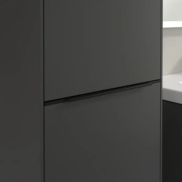 Villeroy & Boch Subway 3.0 Hochschrank - B x T x H: 40 x 36,2 x 171 cm, 1x Klappe mit Wäschekorb, 1x Tür, Graphite, Farbe Griff: Volcano black, DIN Anschlag: Links - Nahaufnahme eines modernen, grauen Badezimmerschranks mit minimalistischem Griff. Stilvolles Design für zeitgemäße Badezimmer.