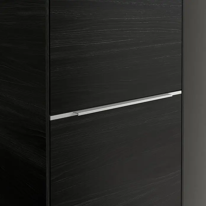 Villeroy & Boch Subway 3.0 Hochschrank - B x T x H: 40 x 36,2 x 171 cm, 1x Klappe mit Wäschekorb, 1x Tür, Black Oak, Farbe Griff: Aluminium glänzend, DIN Anschlag: Rechts - Nahaufnahme eines schwarzen Schranks mit einer horizontalen silbernen Schublade. Das Holz hat eine deutliche Maserung.