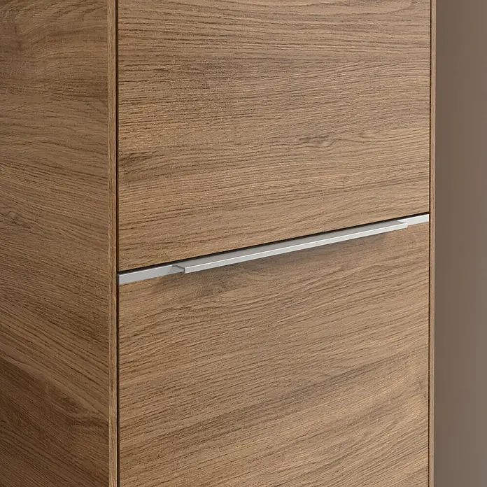Villeroy & Boch Subway 3.0 Hochschrank - B x T x H: 40 x 36,2 x 171 cm, 1x Klappe mit Wäschekorb, 1x Tür, Kansas Oak, Farbe Griff: Aluminium glänzend, DIN Anschlag: Rechts - Nahaufnahme eines Holzschranks mit einem horizontalen, silberfarbenen Griff. Elegantes Design mit einer warmen Holzmaserung.