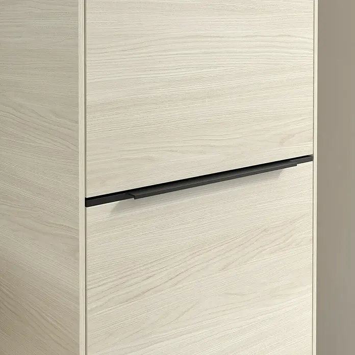 Villeroy & Boch Subway 3.0 Hochschrank - B x T x H: 40 x 36,2 x 171 cm, 1x Klappe mit Wäschekorb, 1x Tür, White Oak, Farbe Griff: Volcano black, DIN Anschlag: Rechts - Naheaufnahme eines modernen Holzschranks mit elegantem, schwarzem Griff, der das schlichte Design des Möbelstücks hervorhebt.