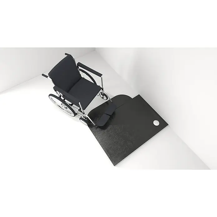 Dusch-Rampe Velto - L x B x H: 104 x 26 x 3,5 cm, Black Stone - Abbildung eines Rollstuhls auf einer schwarzen Rampe in einer Ecke. Die Rampe verbessert die Zugänglichkeit und erleichtert das Manövrieren.